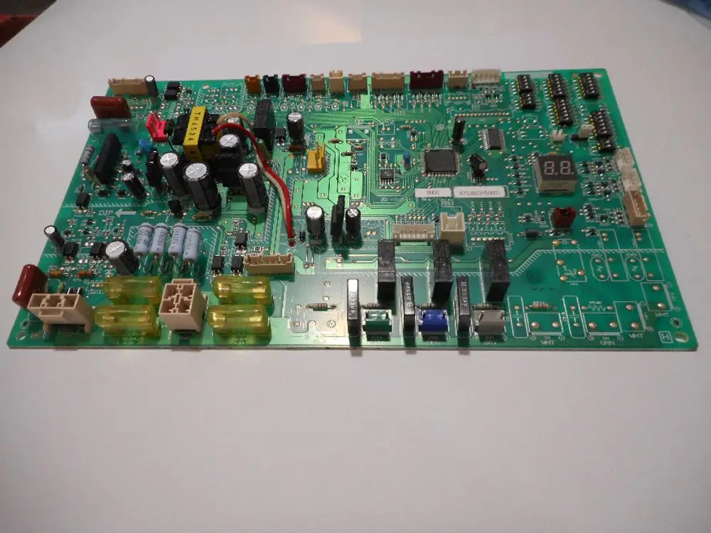 Druckplatine mit elektronischen Bauteilen, darunter Widerstände, Kondensatoren und Schalter, für eine Außeneinheit von Remeha.